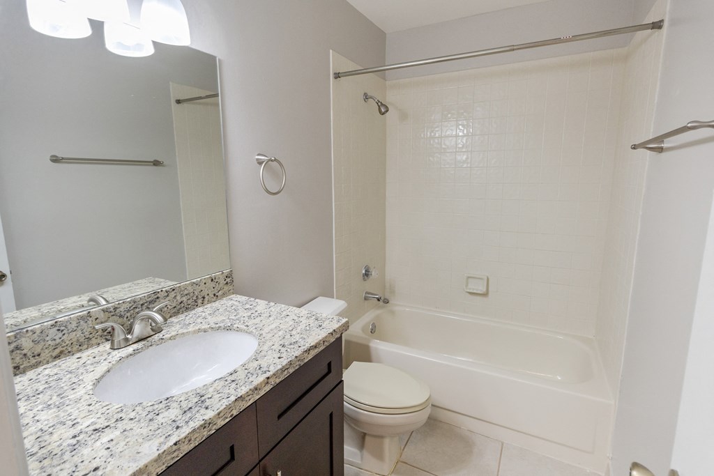A white bathroom with a sink, toilet and bathtub.